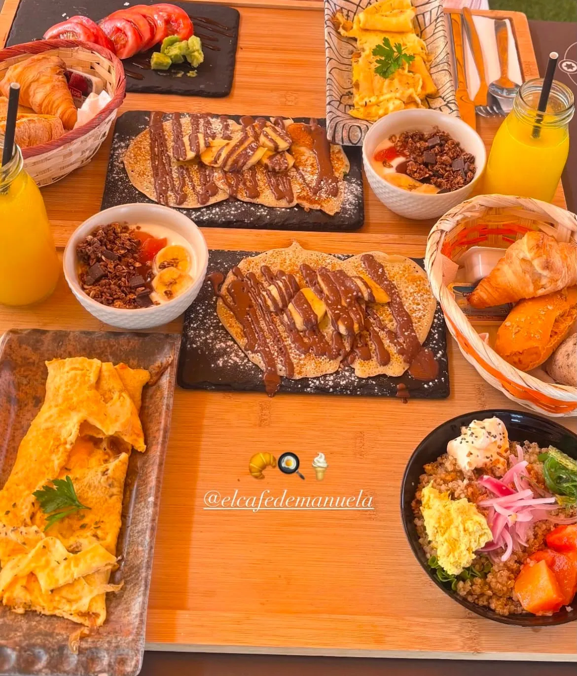 Mesa de brunch con dos tortitas con plátano y chocolate, tortilla, yogures con granola y bol de quinoa
