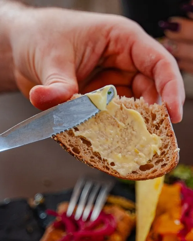 Rebanada de pan artesano con margarina aliñada