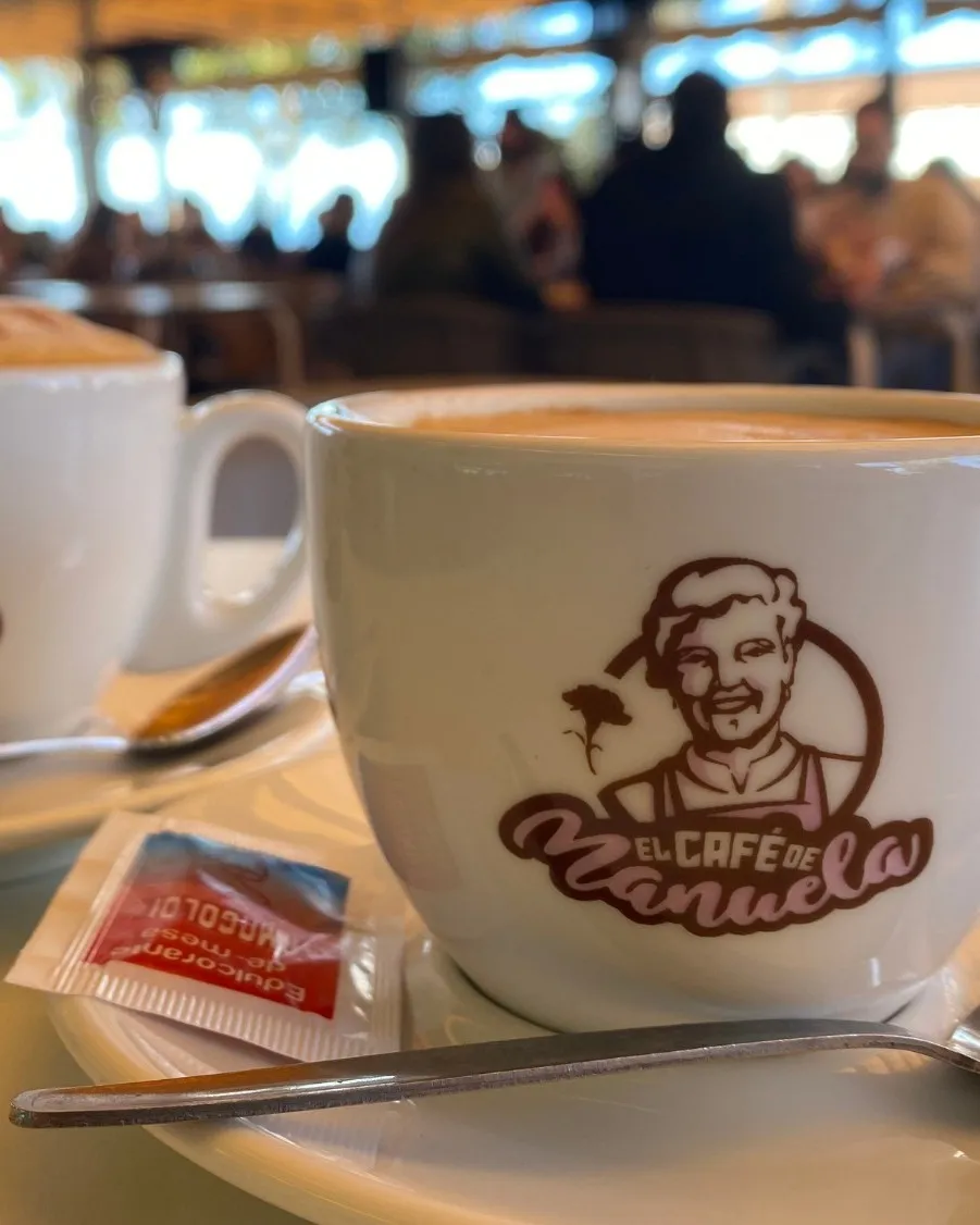 Taza de café con el logo de El Café de Manuela, en la terraza